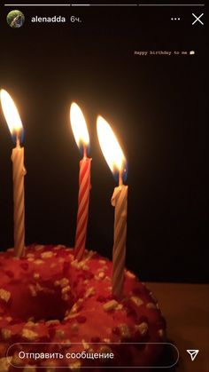 three candles are lit on a cake with red icing and sprinkles