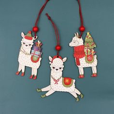 three llamas with christmas decorations hanging from strings