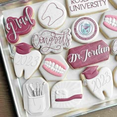 decorated cookies are arranged in the shape of toothbrushes and dental instruments on a tray