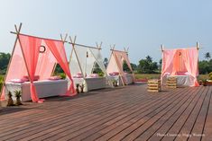 an outdoor ceremony setup with pink and white drapes