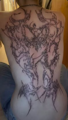 the back of a woman's body with tattoos on it