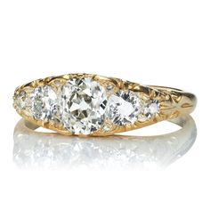 three stone diamond ring in yellow gold with diamonds on the sides and an old - fashioned band