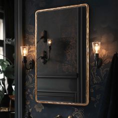 a bathroom with a mirror and two lights on the wall next to a sink in front of a mirror