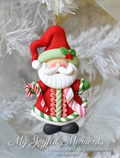 a christmas ornament hanging from a tree with candy canes and santa claus