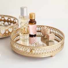 two gold trays with perfume bottles on them