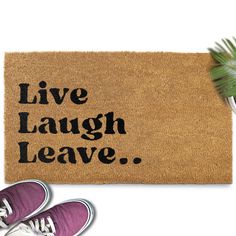 a door mat with the words live laugh leave on it next to sneakers and a plant