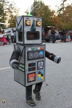 a person in a robot costume walking across a parking lot