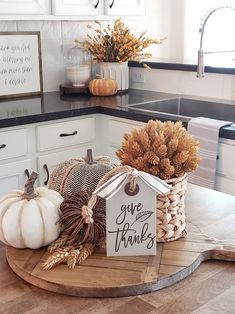 a kitchen counter with pumpkins, gourds and other decorations on top of it