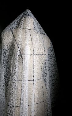 a white lace shawl draped over a black background