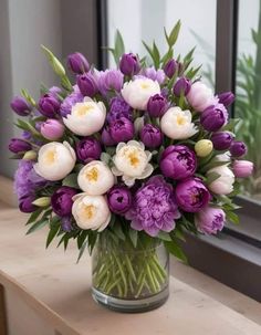 a vase filled with purple and white flowers