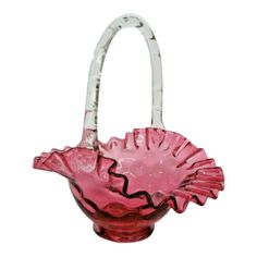 a pink glass vase with a handle in the shape of a flower on it's side