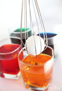 an assortment of different colored drinks in glasses with whisks sticking out of them