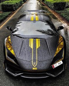 a black and yellow sports car parked on the side of a road with palm trees painted on it