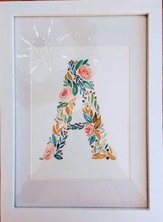 the letter a is made up of flowers and leaves in a white frame with a red border