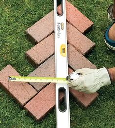 a person measuring bricks with a tape measure