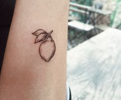 a small tattoo on the wrist of a woman's arm, with an orange