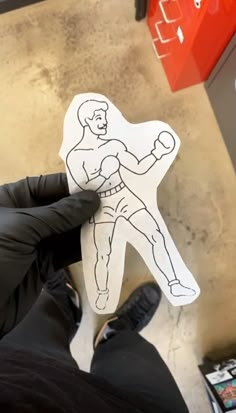 a person holding up a paper cut out of a man