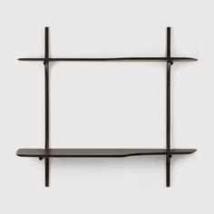 a black shelf with two shelves on each side and one shelf above it, against a white wall