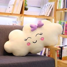 a pillow shaped like a cloud with a bow on its head sitting on a chair