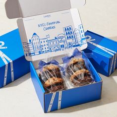 two blue boxes filled with cookies on top of a table