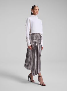 The Tracy Skirt is crafted from our lightweight metallic vegan leather in a silver hue. This midi silhouette features an asymmetrical hem with starburst pleating and ruched detailing at the hip, offering a modern, high-shine update to a classic style. Shop Bottoms. Styling Tip: Offset with a sumptuous knit or a crisp button-down for a balanced, elevated look. Vegan Leather Skirt, Asymmetrical Hem, Asymmetric Hem, Leather Skirt, Vegan Leather, Classic Style, Skirt, Leather, Silver