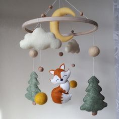 a baby crib mobile with a fox hanging from it's side