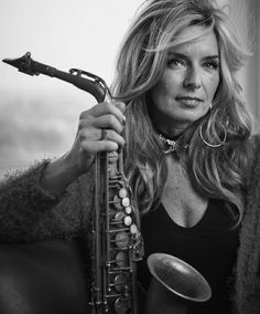 a woman holding a saxophone in her right hand