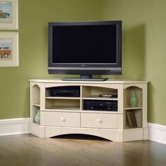 a flat screen tv sitting on top of a white entertainment center next to a wooden floor