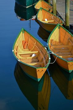 three small boats are tied to the dock