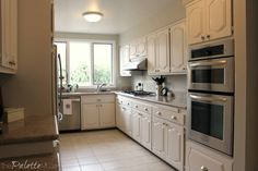 a kitchen with white cabinets and stainless steel appliances