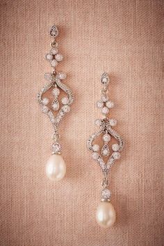 the bride's earrings are adorned with pearls and crystal stones, while the groom is wearing