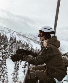 a woman sitting on top of a ski lift