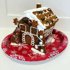 a gingerbread house is on a red plate