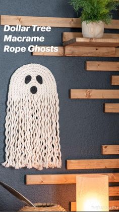 a wall decoration with a ghost made out of yarn and wooden planks on it