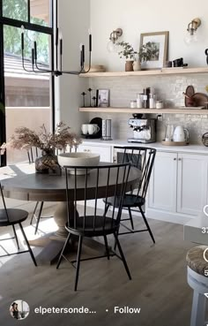 a kitchen filled with lots of white counter top space next to a dining room table