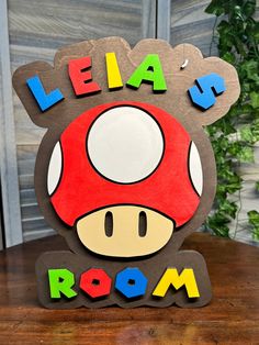 a wooden sign that says, leia up room with a mushroom on it's head