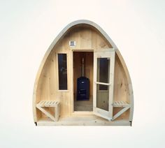 the inside of a wooden sauna with two benches on each side and an open door