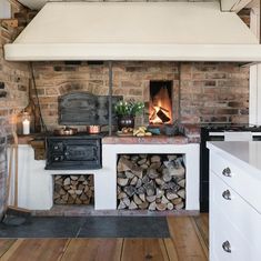 an old fashioned stove with logs stacked in front of it