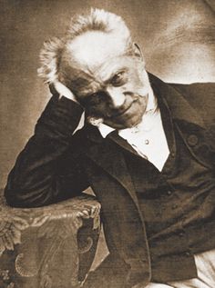 an old black and white photo of a man in a suit sitting on a chair