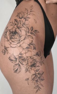 a woman's thigh with flowers on it and her cell phone in her hand