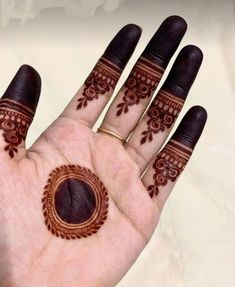 a person's hand with henna tattoos on their palms and hands, all painted brown