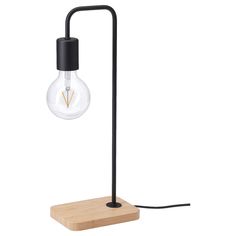 a light that is on top of a wooden block and has a black cord attached to it