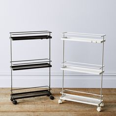 two metal shelving racks sitting on top of a wooden floor next to each other