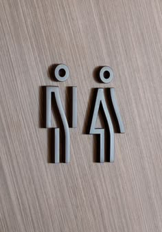 two wooden signs on a wood surface with no people around them, one is for women and the other is for men