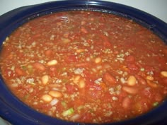 a blue bowl filled with chili and beans