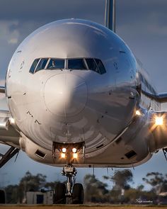 an airplane that is sitting on the runway with its lights on and it's landing gear down