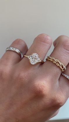 a woman's hand with three different rings on it