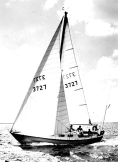 an old photo of a sailboat in the ocean with two men on it's side