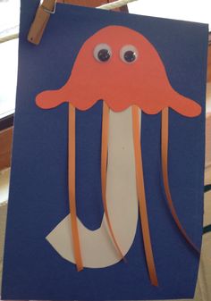 an octopus made out of construction paper on a blue board with orange tape and eyes