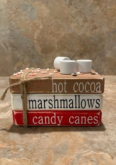 two marshmallows sitting on top of a box with candy canes in it